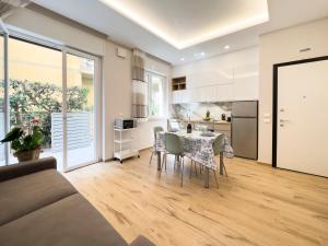 利多迪卡马约雷Versilia Residence - Fronte Mare的厨房以及带桌椅的起居室。