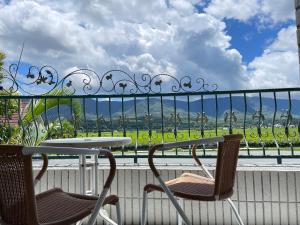池上假期民宿的美景阳台配有一张桌子和两把椅子