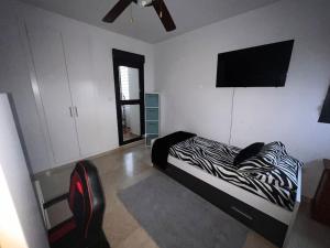 阿尔沃洛特Casa con picina en Granada.的一间卧室配有斑马打印床和平面电视