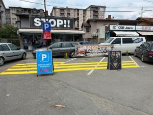 新帕扎尔Avio Apartmani 2018的停车场,汽车前有停车标志
