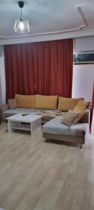 安塔利亚Konyaaltı Apart Hotel的客厅配有两张床和红色窗帘