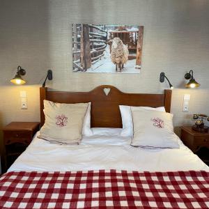 科特雷金狮大酒店的一张带两个枕头的床和一张羊的照片