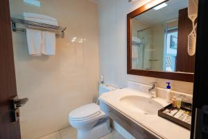 下龙湾Topone Halong Hotel的一间带水槽、卫生间和镜子的浴室