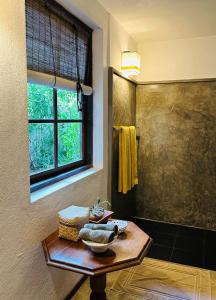 乌纳瓦图纳乌纳瓦图纳杜内斯酒店的一间带桌子和淋浴及窗户的浴室