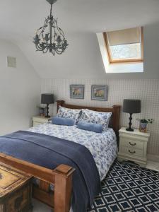 沃特福德Faithlegg Hotel Lodge的一间卧室配有一张带蓝色床单和吊灯的床。