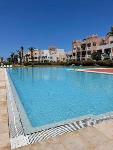 萨伊迪耶Appartement en résidence + grande terrasse sur le toit的一个大型蓝色游泳池,其建筑背景为: