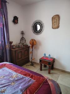 雷居斯Villa près des remparts的一间卧室配有一张床、一张桌子和一面镜子