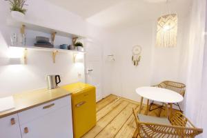 霍夫Zentrale 1-Zimmer-Ferienwohnung mit digitalem Check in的厨房配有黄色橱柜和桌子