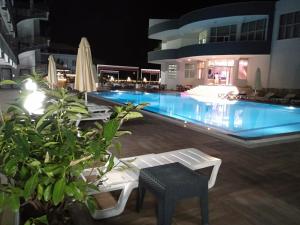 帕莫卡莱ANYA RESORT HOTEL的游泳池在晚上配有桌椅
