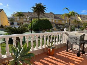 美洲海滩El Camison Apartment的阳台拥有白色的围栏和棕榈树。