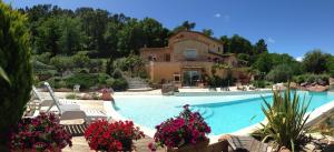 弗雷瑞斯Un petit paradis en Provence的房屋前有游泳池的房子