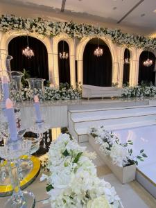 苏尔阿尔阿伊加广场酒店的宴会厅,配有白色的鲜花和白色的长椅