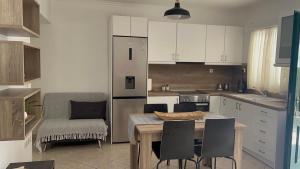 阿达玛斯Asterias Studios的一间带桌椅的厨房和一间带白色橱柜的厨房