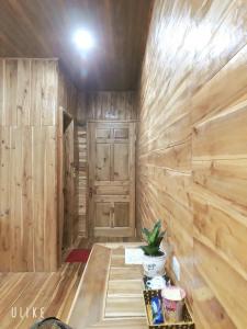 宁平Tuyet's hostel的一间设有木墙和门的房间