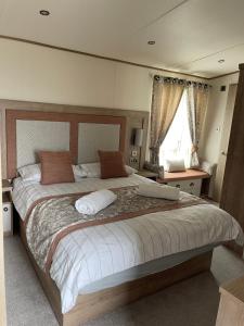 威尔汉姆2-6 guests Holiday Home in Durdle Door的一间卧室设有一张大床和一个窗户。