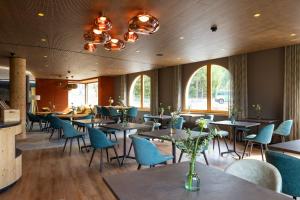 蓬特雷西纳加尼切萨穆林酒店的餐厅设有桌椅和窗户。