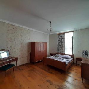 阿纳克利亚Ani's Green House的卧室配有床、书桌和钢琴