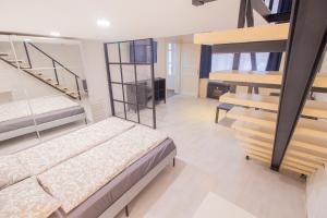 布达佩斯Industrial Double Loft Apartment的一间带两张双层床的卧室和楼梯