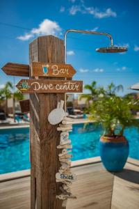 克拉伦代克Bloozz resort Bonaire的木标,带有酒吧潜水中心和游泳池