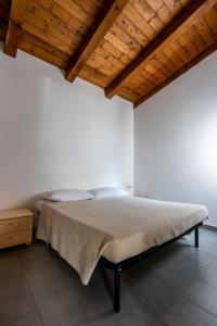 基奥贾La Conchiglia的白色客房的一张床位,设有木制天花板