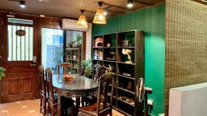 河内Harmony Homestay - Hanoi Homestay in Old Quarter的一间设有桌子和绿色墙壁的用餐室
