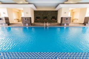 马尼拉Pacific Bay Grand Suites的蓝色水中的酒店的游泳池