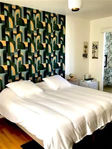 塞夫里耶VUE LAC LODGES的一间卧室配有一张白色大床和色彩缤纷的床头板