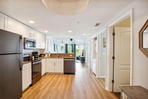 圣徒皮特海滩Sunset Vistas 407S的厨房铺有木地板,配有白色橱柜。