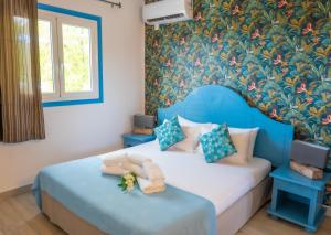 德赛Résidence Vue Mer的一间卧室设有蓝色的床和花卉墙