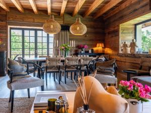 巴斯洛内特Superbe ferme rénovée en chalet de luxe en PLEINE NATURE的用餐室设有桌椅和窗户。