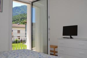 卡尔多纳佐Ca' del Lauro的一间卧室设有滑动玻璃门和电视