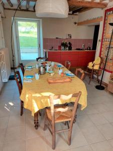 Chambres d'hôtes au calme的厨房里的一张桌子,上面有黄色的桌布