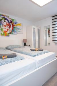 梅明根#3 bequemes Zimmer mit Pool und Garten的白色客房的两张床,墙上挂有绘画作品