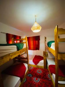 塔哈佐特Rayane Guest House的客房设有三张双层床和吊灯。