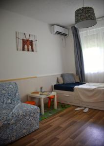 凯斯特海伊Helikon 32 Apartman Keszthely的一间卧室配有一张床、一把椅子和一张桌子
