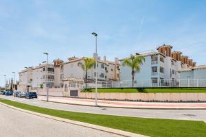 拉马丽娜Playa del Pinet Apartment的一条街道前方有建筑和棕榈树