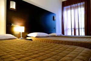 努斯科科卢奇酒店的酒店客房设有两张床和窗户。