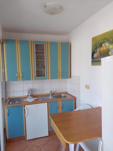 塞尔瑟House Marko的厨房配有蓝色橱柜和木桌