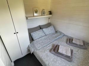 ĶesterciemsPiejūras Kaķīšu namiņš的小房间设有一张床和两个枕头