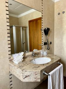 安特克拉罗斯多蒙那斯酒店的一间带水槽和大镜子的浴室
