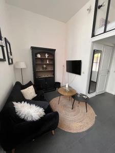 里尔Au cœur du VIEUX-LILLE : Charmant appartement的客厅配有黑色沙发和桌子