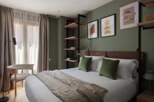 巴塞罗那TOC Hotel Las Ramblas的一间卧室配有一张带绿色墙壁的床和一把椅子