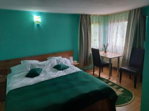 内霍瓦蒙大拿旅游酒店的绿色卧室配有床和桌子
