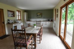 KentSHEPHERDS HUT的厨房配有长木桌子和椅子