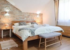 普利特维采村B&B Villa Plitvica的一间卧室设有一张大床和砖墙