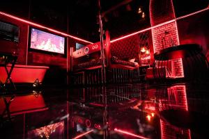 格但斯克Grey Secret Champagne Apartament Spa的一间设有红灯和桌子的酒吧的房间