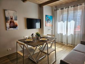 塞斯特雷Moda Apartments 69的一间带桌椅和电视的用餐室