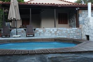 KamariótisΜουριές的一个带木甲板和房子的游泳池