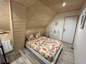 CordéacLe cocoon Isérois, avec balnéo的木制客房内的一间卧室,配有一张床