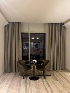 利雅德Cozy studio in Damac toweres的客房设有桌子、两把椅子和窗户。